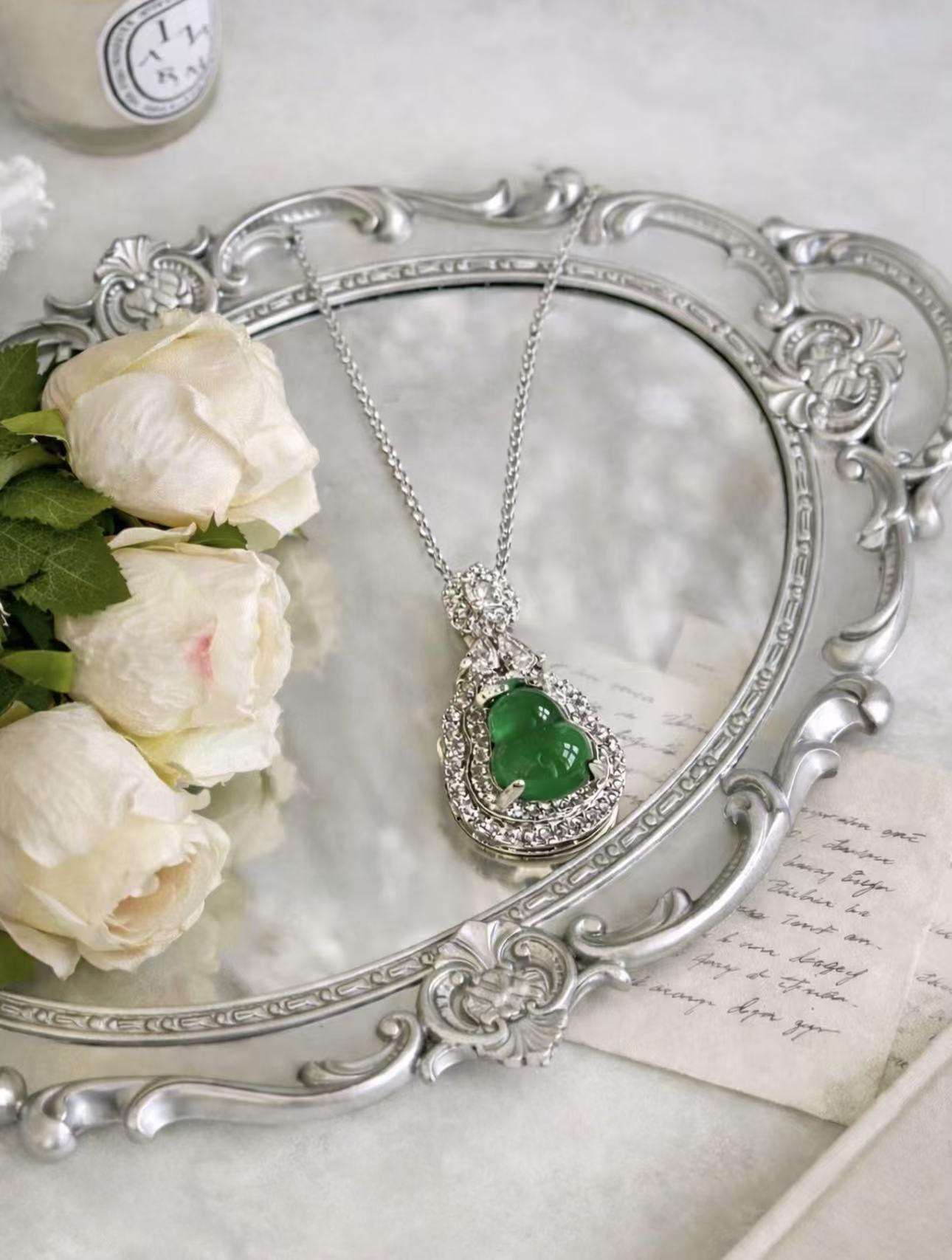 Green pendant styled with silver and white roses